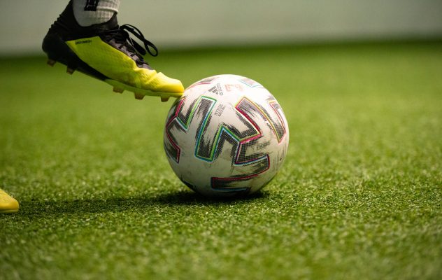 Detailaufnahme eines Spielerbeins und eines Balls