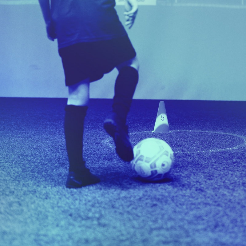 Detail shot of a kid in the skills.lab Arena with a ball on his right foot